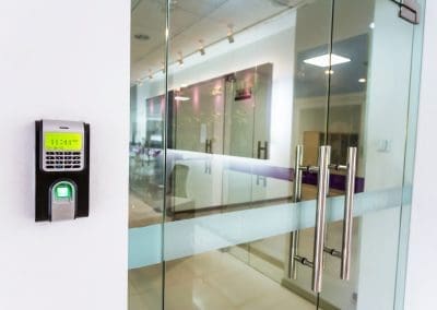 Access control systems featuring fingerprint scanner securing modern glass office entrance