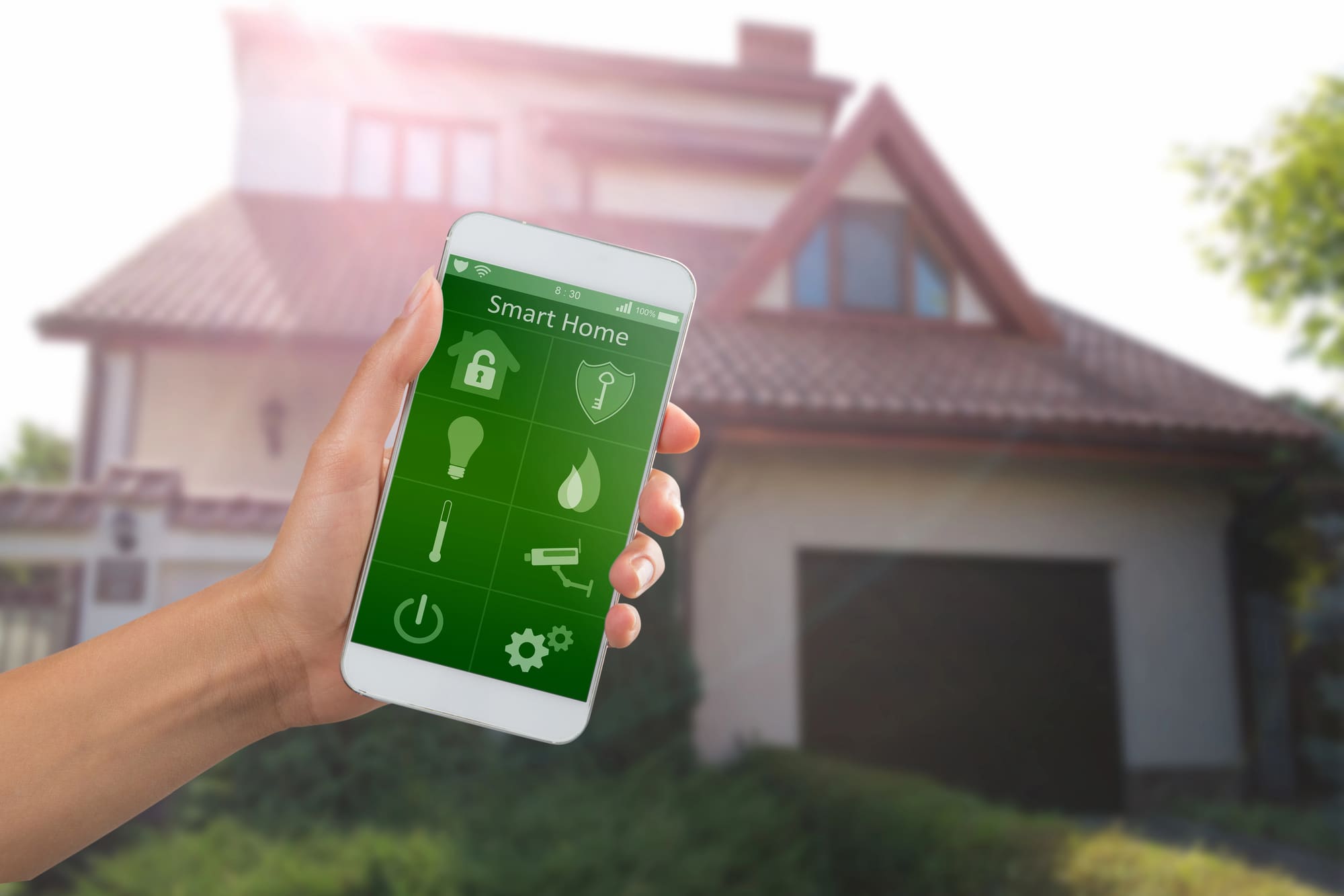 smart home installation Cleveland smart Smart home installation Cleveland app on smartphone controlling security and lighting with house in background.