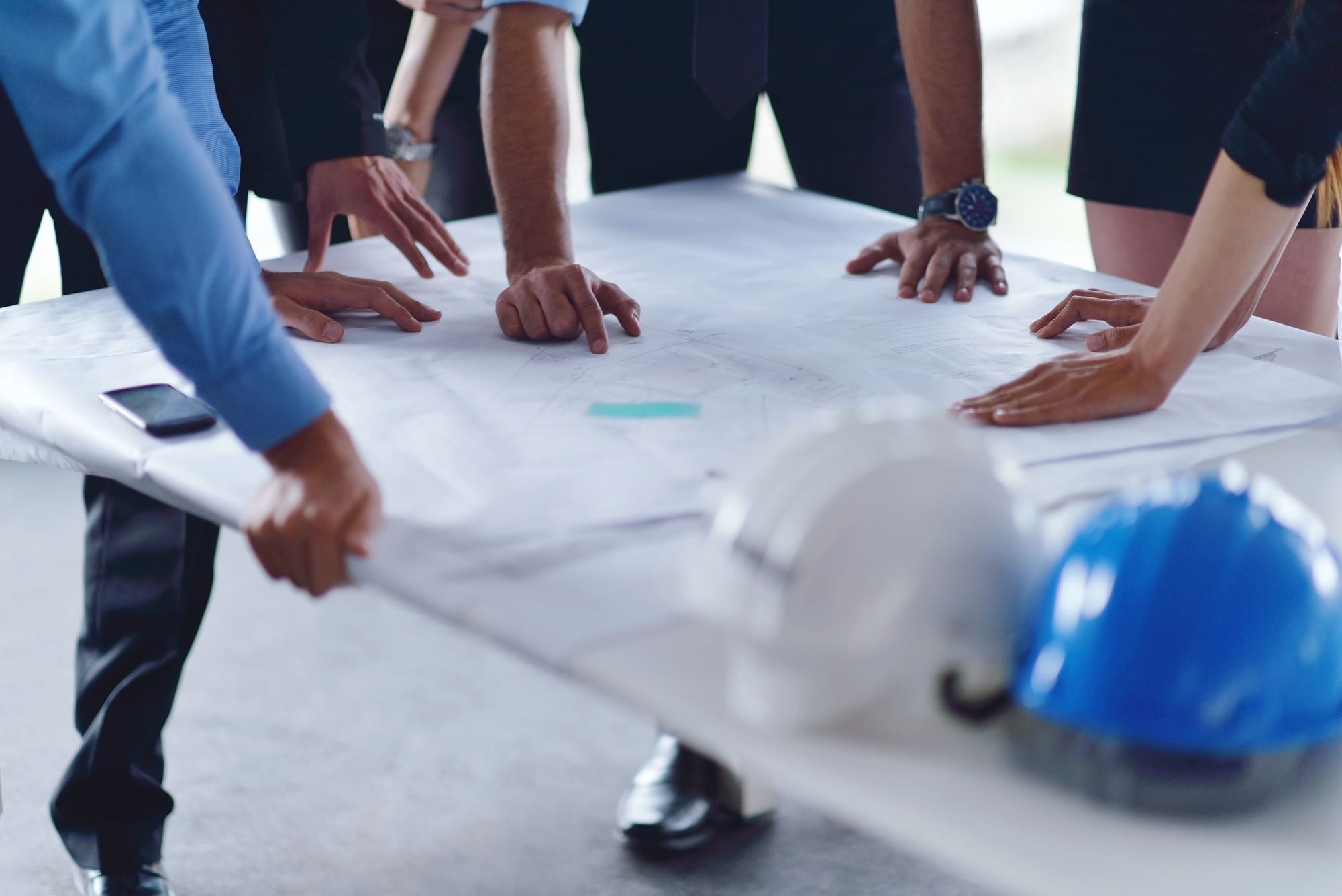 Commercial fire alarm installation Cleveland planning meeting with blueprints and safety helmet